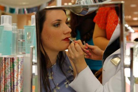 A makeup consultant applies Pop Passion red lipstick onto Makayala Jones' lips. 